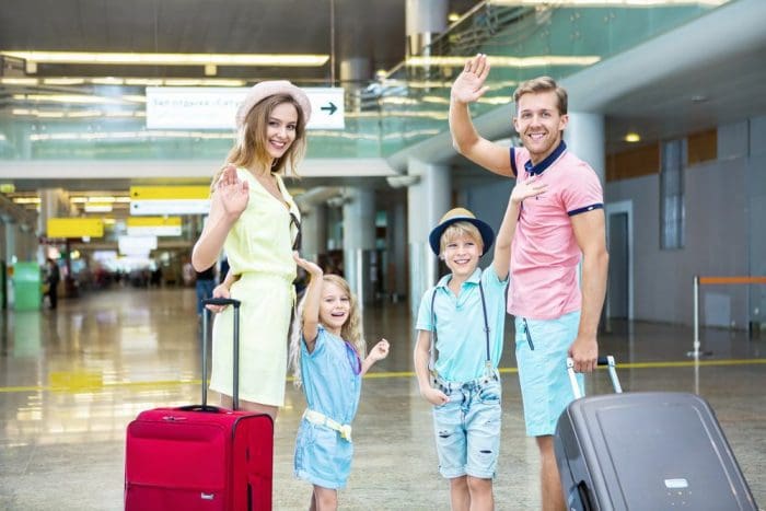 Happy family with a suitcase at the airport