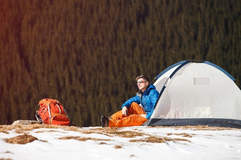 Hiker in tent on mountainside