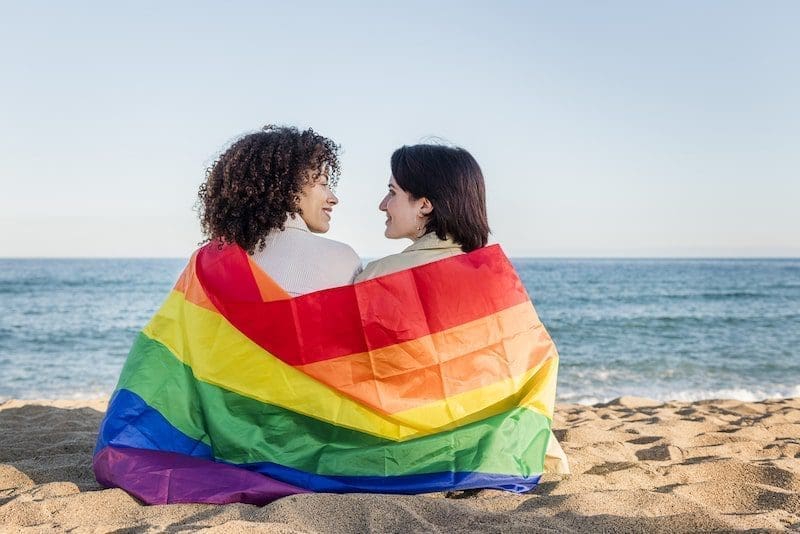 Lesbian couple about to kiss in front of the sea