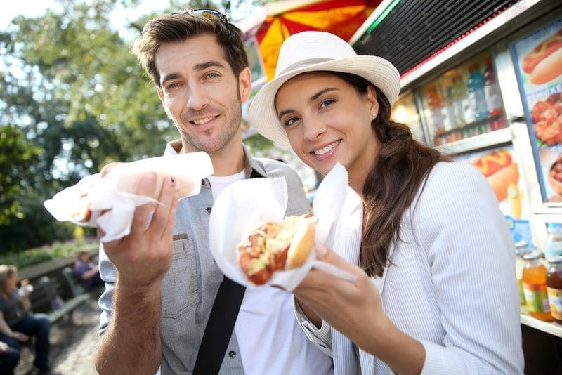 Tourists in New York eating hot dogs