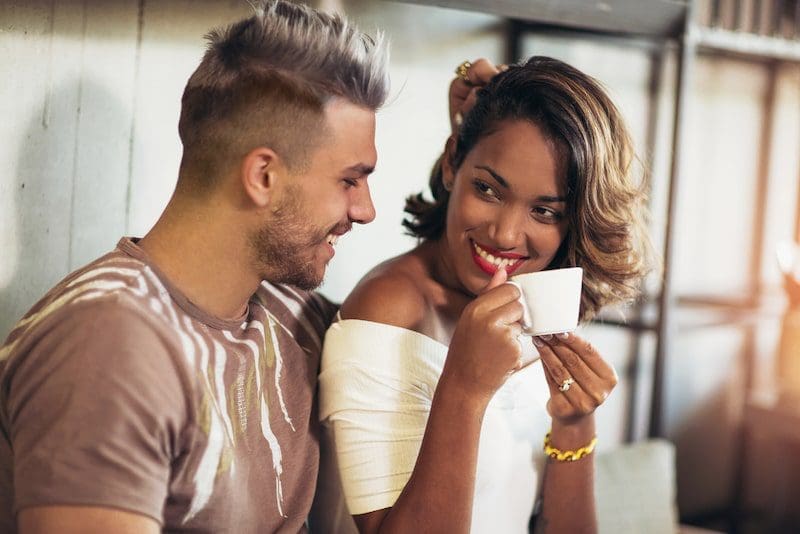 Two happy mixed race couple having fun at the coffee shop