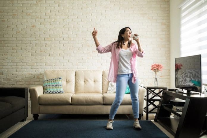 young adult dancing at home smartphone
