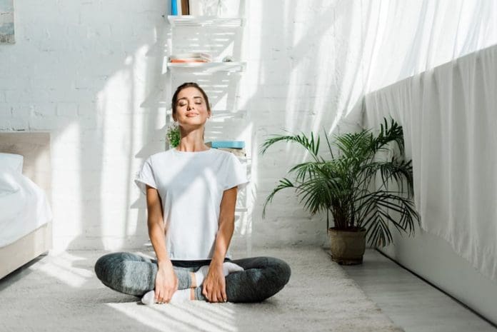 Beautiful happy girl with closed eyes practicing yoga in lotus