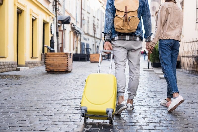 Cropped view of couple holding hands and traveling together