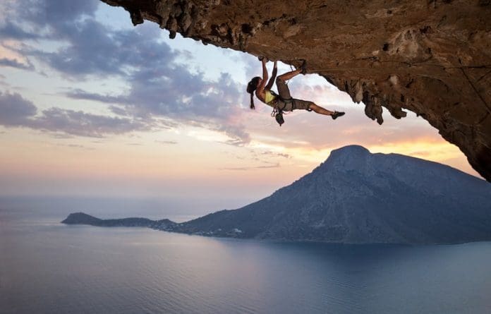 Young female rock climber at sunset Greece