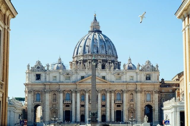white concrete building with flags on top during daytime St Peter Basilica Vaticano Vatican City