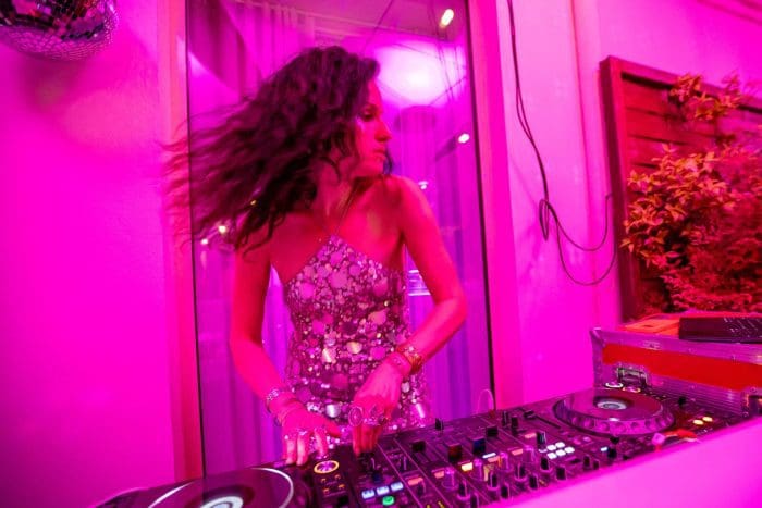 DJ spinning neon pink lighting Hamptons
