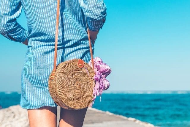 Woman with fashionable stylish rattan bag outside