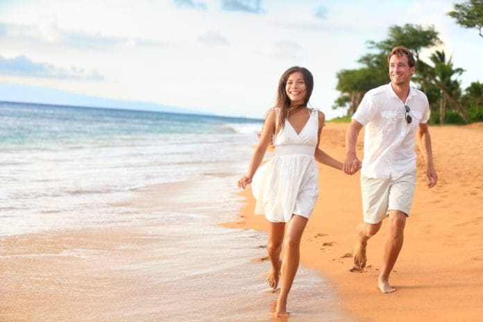 couple walking on beach romantic honeymoon