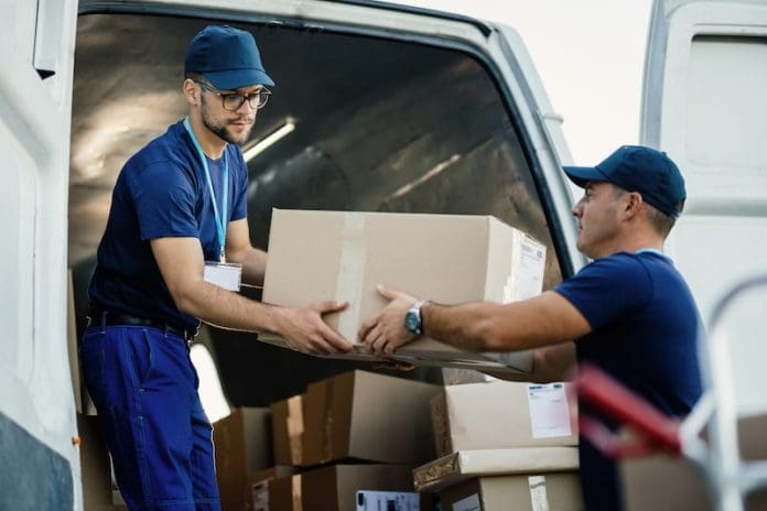 delivery men loading carboard boxes van while getting ready shipment