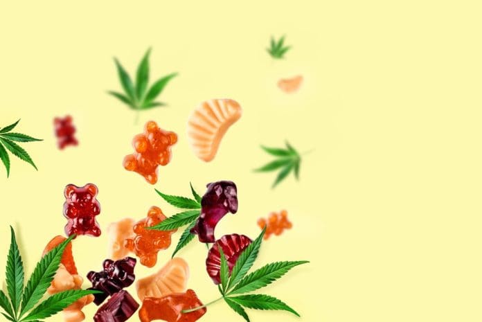 Colored gummies fly along with cannabis leaves