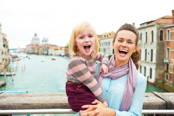 Portrait of happy mother and baby girl standing on bridge