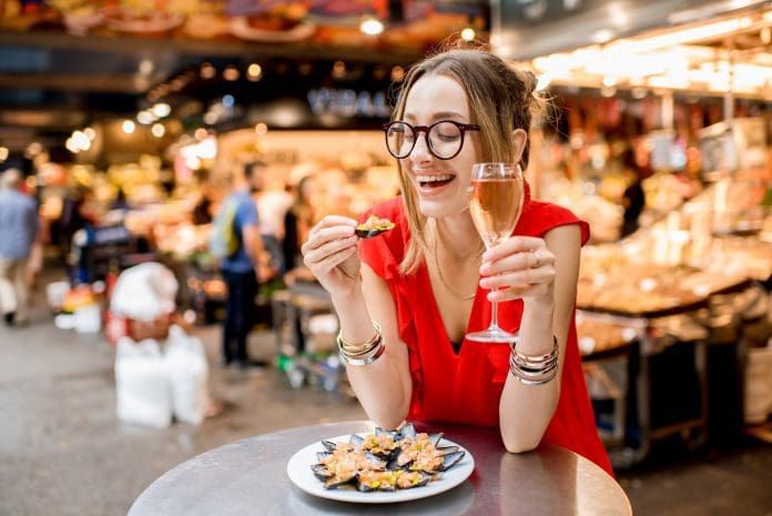 woman enjoying meal at table restaurant wearing red shirt
