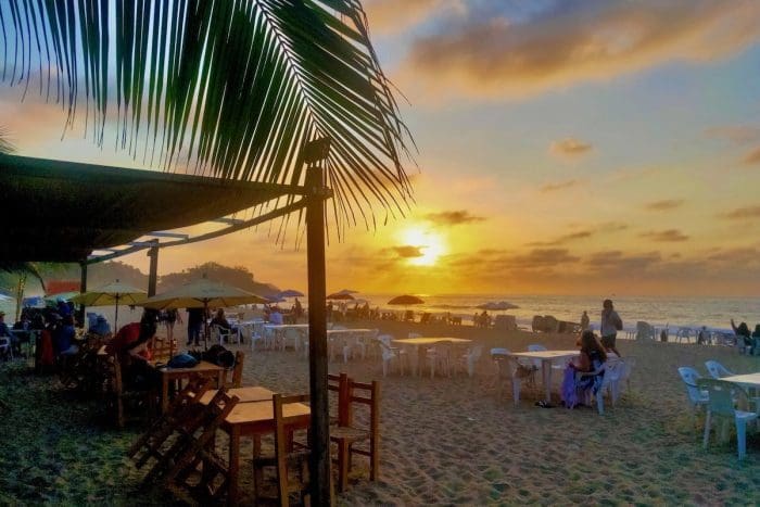 beautiful beach at sunset with tables outside on sand