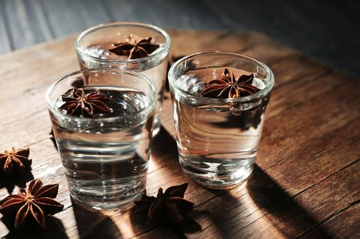 Sambuca with anise on wooden board