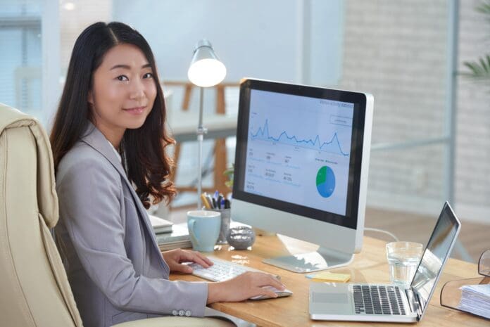 smiling-asian-woman-sitting-desk-office-working-financial-report