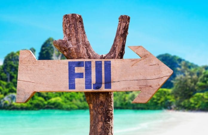 Fiji wooden arrow sign beach background