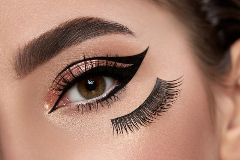 Female eye with cat eye eyeliner looking to camera with false eyelashes