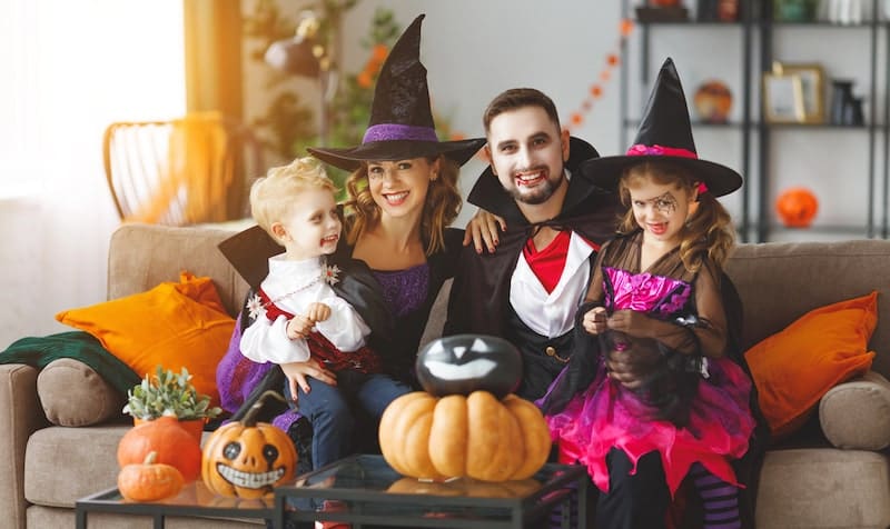 Happy family mother father and children in costumes