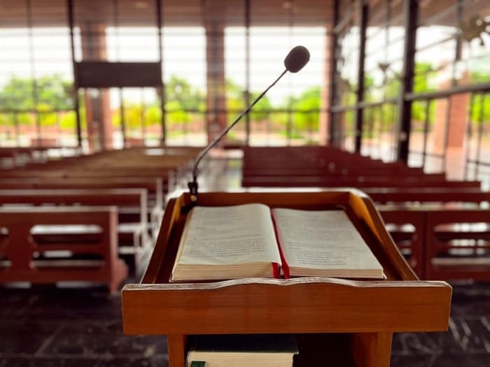 A wooden lectern with an open book inside a church