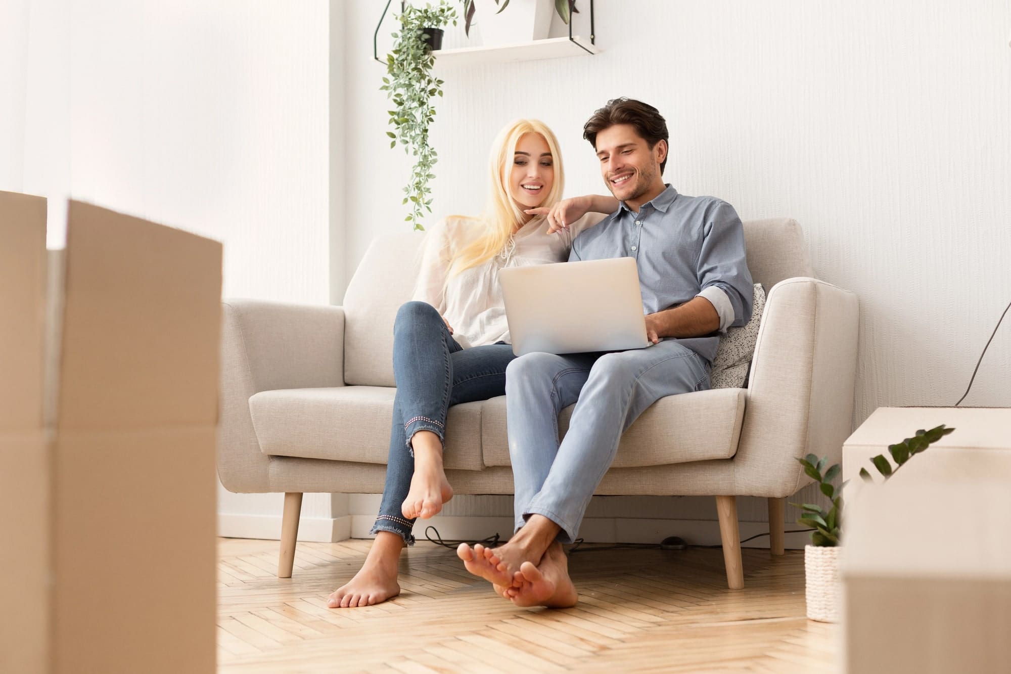Relaxed Young Man And Woman Using Laptop Sitting On